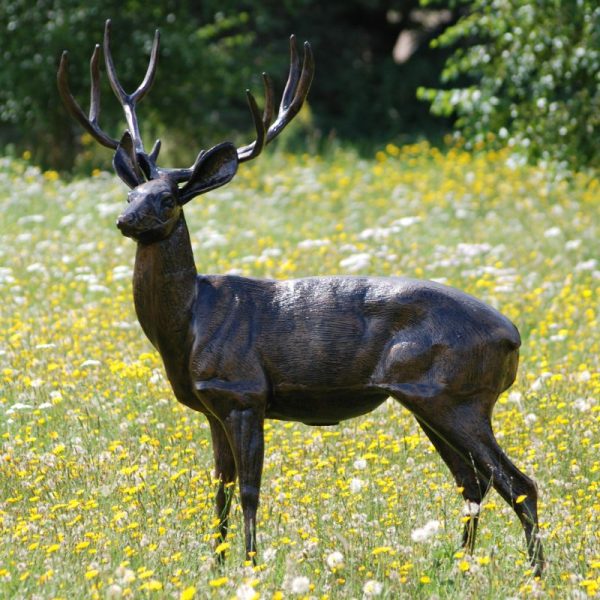 Standing stag life size statue in a flower field